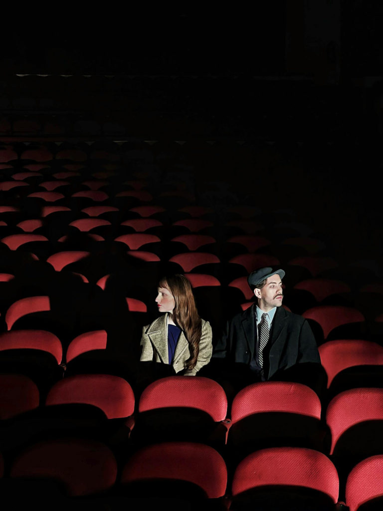 Un homme et une femme dans un théâtre dos à dos