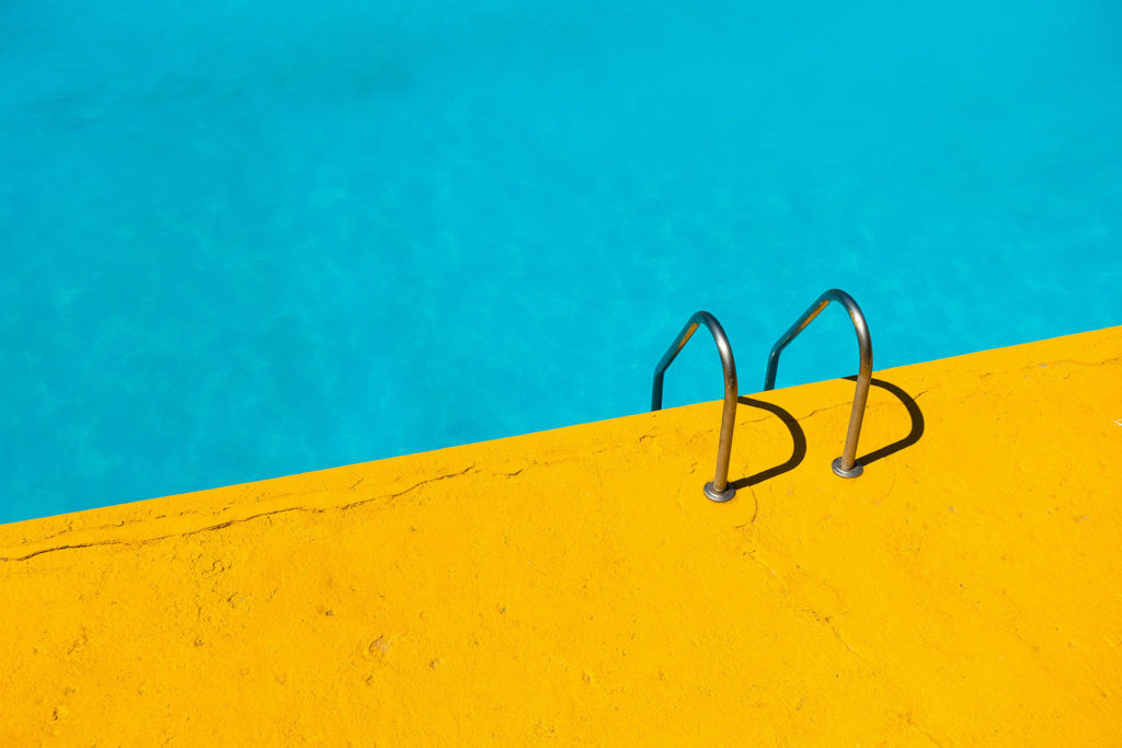 Piscine avec plongeoir. Ligne droite dans l'image, un côté bleu, un côté jaune.